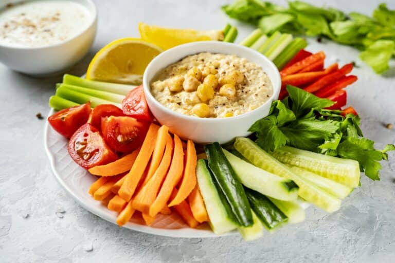 Crop shot of plate with colorful healthy sliced vegetables and dips